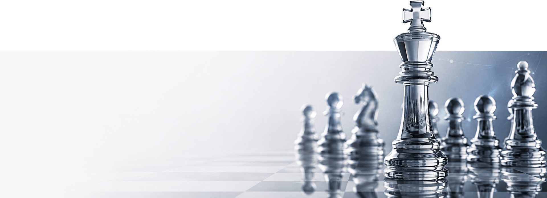 A tall glass chess king standing prominent among smaller glass chess pieces on a board